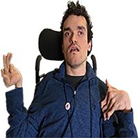 A person with short, curly, black hair, wearing a black shirt and a blue jacket, using a wheelchair.