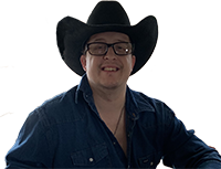 A smiling person wearing a black cowboy hat, glasses, and a blue jean shirt.