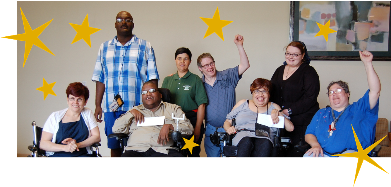 A smiling group of people, some standing, others using wheelchairs, with stars around  them.